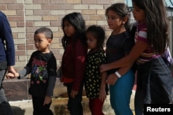 FILE - Children form a line as undocumented immigrant families are released from detention at a bus depot in McAllen, Texas, June 22, 2018.