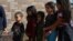 Children form a line as undocumented immigrant families are released from detention at a bus depot in McAllen, Texas, June 22, 2018. 