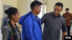 Mendikbud Anies Baswedan (kanan) memakaikan jaket untuk salahsatu guru yang akan mengajar di kabupaten Puncak propinsi Papua, Minggu (24/5). (VOA/Munarsih Sahana)