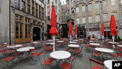 En esta imagen de archivo, tomada el 18 de marzo de 2021, mesas vacías en una plaza desierta en una zona normalmente bulliciosa de la ciudad vieja de Colonia, Alemania.