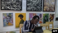 FILE—Artist member of “Art for Memories” team, Manzi Yvan Bryan, 19, works on a portrait of a victim of the Rwandan genocide in Kigali on April 2, 2024.