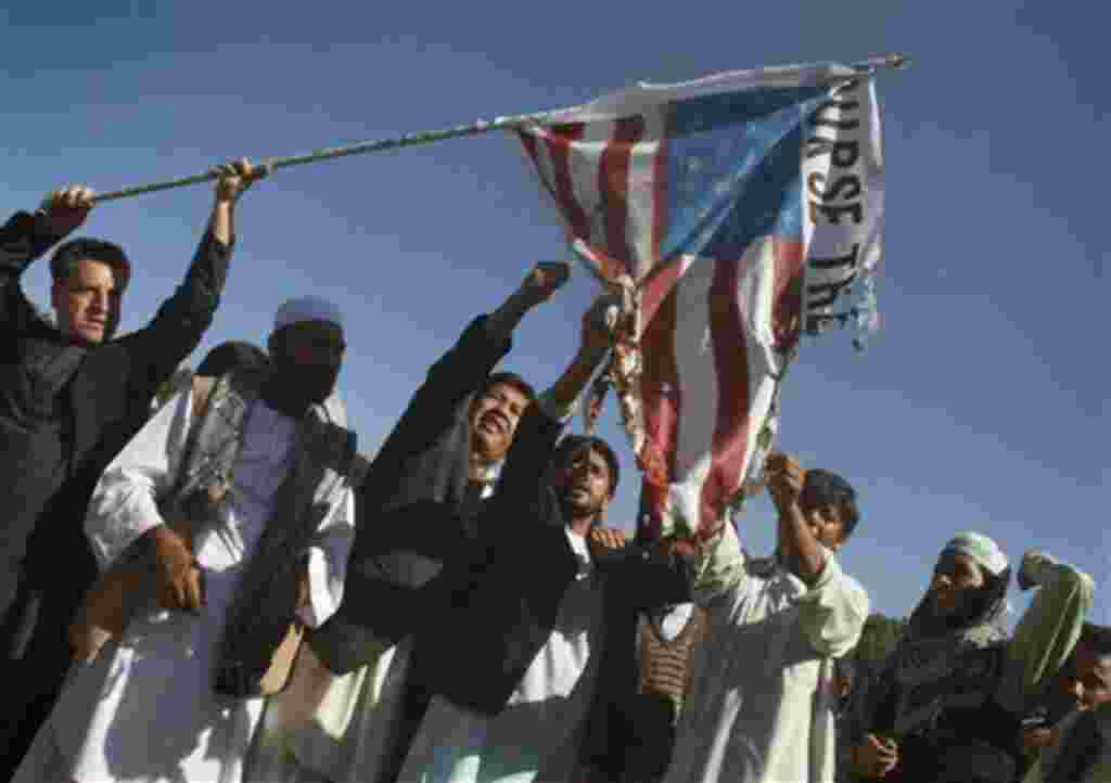 Afghans burn a US flag during an anti US demonstration in Herat west of Kabul, Afghanistan on Friday, April. 1, 2011. Eight foreigners were killed on Friday after demonstrators protesting a reported burning of the Muslim holy book stormed a United Nation