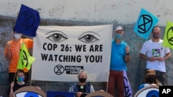 Des militants d'Extinction Rebellion manifestent sur la plage de Muizenberg au Cap, en Afrique du Sud, le 6 novembre 2021.