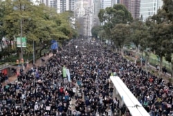 FILE - Protestors raise their hands to show 'five key demands' in Hong Kong, Wednesday, Jan. 1, 2020.