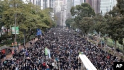 Protesters raise their hands to call for five key demands in Hong Kong, Jan. 1, 2020. Protests that began in June over a proposed extradition law have spread to include demands for more democracy and other grievances. 