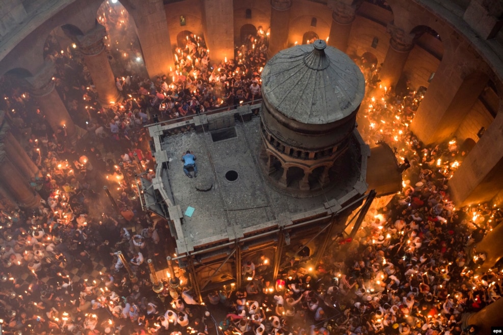 Orthodox Christian worshipers at the Tomb of Christ as the miracle of the Holy Fire occurs in the Church of the Holy Sepulchre, Jerusalem, Israel, April 30, 2016. Eastern Orthodox Christians believe the Holy Fire, which emenates from within the Tomb of Christ and quickly spreads around the church and outside to Jerusalem and even to foreign countries, represents the flame of the Resurrection power, as well as the fire of the Burning Bush of Mount Sinai.