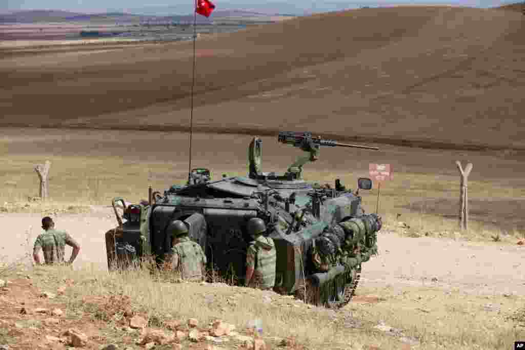 Turkish soldiers watch the fighting between Islamic militants and Kurdish forces to the west of Kobani, Syria, at the Turkey-Syria border near Suruc, Turkey, Sept. 30, 2014. 