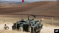 Binh sĩ Thổ Nhĩ Kỳ theo dõi cuộc giao tranh giữa các chiến binh Hồi giáo và chiến binh người Kurd ở phía tây Kobani, Syria, từ biên giới Thổ Nhĩ Kỳ-Syria.