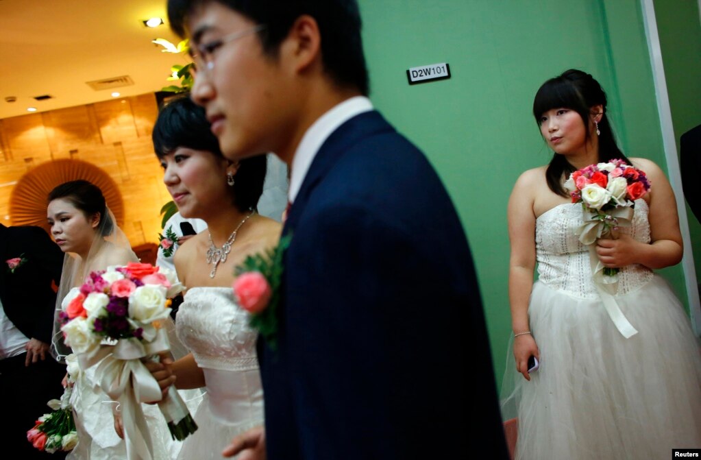 上海郊区，一对新人等待参加婚介公司组织的集体婚礼（2013年5月18日）