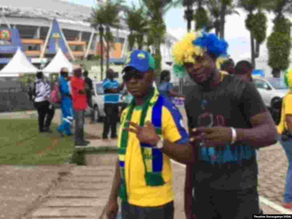 Deux fans gabonais devant le stade de Libreville sûrs d&#39;une victoire gabonaise contre la Guinée Bissau près du stade de l&rsquo;Amitié à Libreville, Gabon, 14 janvier 2017. (VOA/Timothée Donangmaye)
