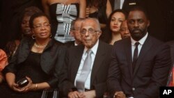 FILE - UMnu. Ahmed Kathrada, center, umkaNelson Mandela, UGracia Machel lomlingisa uMnu. Idris Elba, babukele umdlalo omayelana loMandela.