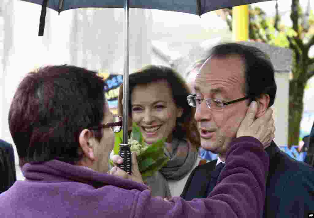 El candidato socialista y vencedor de las elecciones en Francia, Francois Hollande y su coma&ntilde;era, Valerie Trierweiler, son saludados por votantes. (AP)