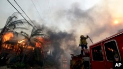 Petugas pemadam kebakaran Los Angeles County bersiap untuk memadamkan titik api di kawasan Lake View Terrace, Los Angeles, 5 Desember 2017.