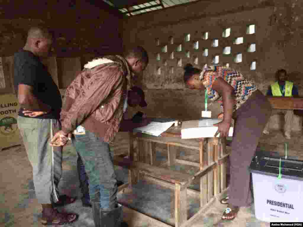 Polling station employees inspect voter ballot, Oct. 26, 2017. (Photo: VOA Swahili service)