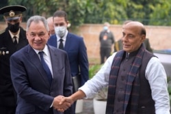 Indian Defense Minister Rajnath Singh, right, shakes hand with his Russian counterpart Sergey Shoygu in New Delhi, Dec. 6, 2021.