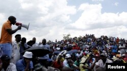 Striking miners listen to an address by their leader at the AngloGold Ashanti mine in Carletonville, northwest of Johannesburg, October 19, 2012. 