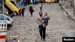 FILE - A man cries as he carries his daughter while walking from an Islamic State-controlled part of Mosul toward Iraqi special forces soldiers during a battle in Mosul, Iraq, March 4, 2017.