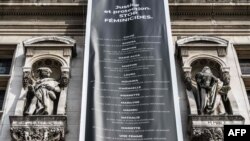 FILE - A banner listing names of domestic violence victims hangs from Paris' city hall during a protest dedicated to the memory of women killed by their spouses or ex-spouses in 2019 and against violence against women, in Paris, Aug. 28, 2019.