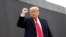 Donald Trump raises his fist as he visits the U.S.-Mexico border wall,