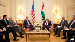 U.S. Secretary of State John Kerry, center left, sits with Palestinian President Mahmoud Abbas, during their talks in Paris, France, Feb. 19, 2014. 