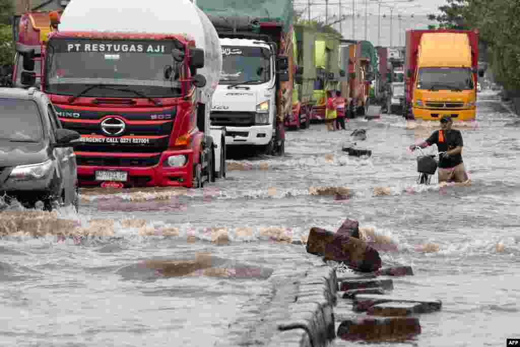 A man wades through floodwaters following heavy rainfall in Semarang, Central Java.