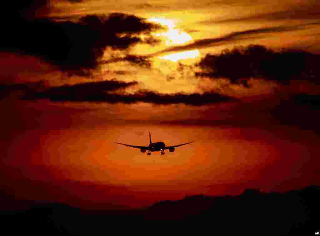 An aircraft approaches the airport in Frankfurt, Germany, as the sun rises.