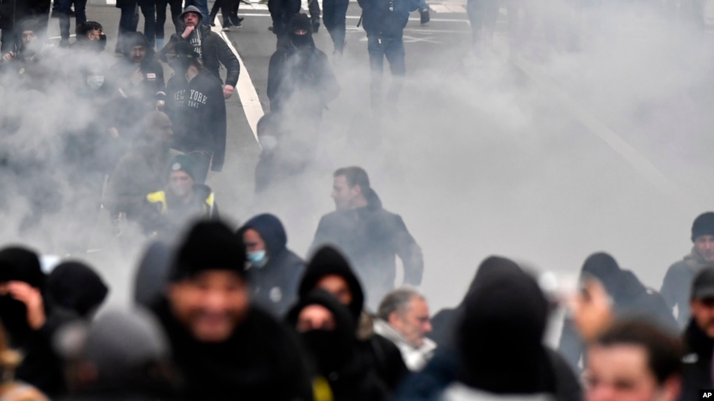 Polisi anti huru hara menggunakan gas air mata untuk membubarkan demonstran selama protes terhadap tindakan virus corona, di Brussels, Belgia, 5 Desember 2021. (Foto: AP)