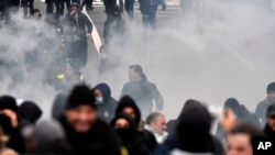 Riot police use tear gas to disperse demonstrators during a protest against coronavirus measures, in Brussels, Belgium, Dec. 5, 2021. 