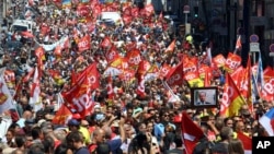 Workers hold flags and demonstrate during a day of strikes and protests, in Marseille, southern France, June 14, 2016. 