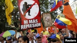 Manifestantes portan carteles durante una marcha antigubernamental este sábado en Caracas.