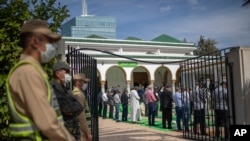 FILE - A subordinate   of information    forces stands defender  portion    Muslim worshipers queue to participate  a mosque for Friday prayers successful  Rabat, Morocco, Oct. 16, 2020.