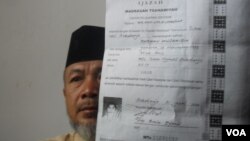 Hamim, pengurus pondok pesantren Al Mukmin di Ngruki, memegang ijazah salah satu pelaku teror di Solo. (VOA/Yudha Satriawan)