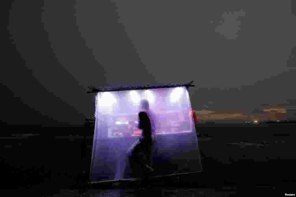 A vendor makes fast food for customers at a mobile cart on a rainy evening in Colombo, Sri Lanka, April 18, 2019. 