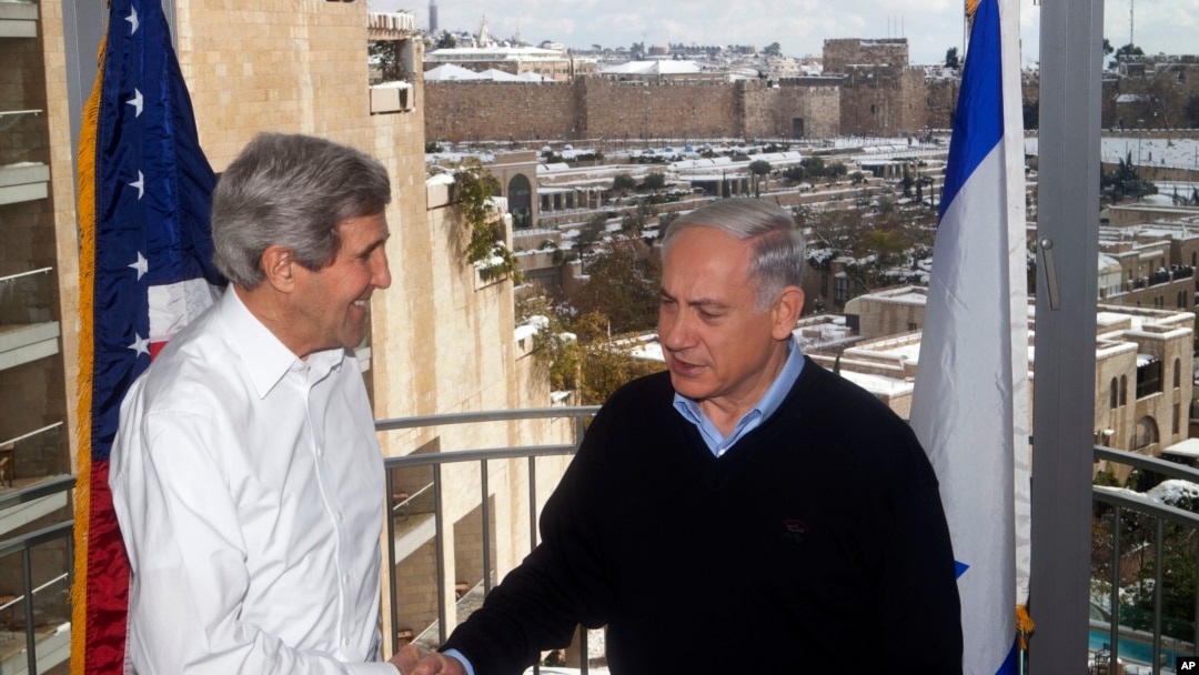 Menlu AS John Kerry (kiri) berjabat tangan dengan PM Israel Benjamin Netanyahu dalam pertemuan mereka di Yerusalem 13/12/2013. 