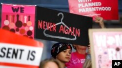 En esta imagen de archivo, tomada el 21 de mayo de 2019, August Mulvihill, de Norwalk, Iowa (centro), sostiene un cartel durante una manifestación contra la ley del aborto ante la Cámara de Representantes estatal, en Des Moines, Iowa. 