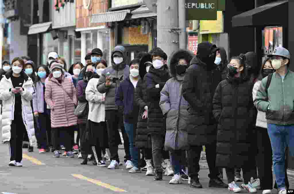 People wait in line to buy face masks at a store in the Dongseongro shopping district in Daegu, South Korea. South Korea reported 334 new cases of the coronavirus cases, pushing its total to 1,595 — the largest in the world outside of China.
