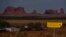 FILE - In this April 30, 2020, photo, a sign marks Navajo Drive as Sentinel Mesa, homes and other structures in Oljato-Monument Valley, Utah on the Navajo Reservation, stand in the distance. 