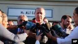 Turkey's President Recep Tayyip Erdogan, center, talks to members of the media outside a mosque following Eid prayers in Istanbul, Sept. 1, 2017.