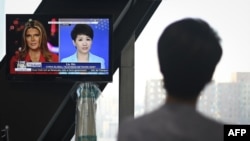 中國環球電視網主播劉欣在北京的央視總部觀看她自己與美國福克斯商業頻道主播翠西·裡根進行電視辯論的錄像。（2019年5月30日）