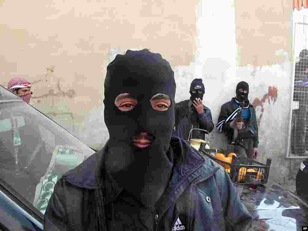 Syrian Free Army fighters stand on guard in a neighborhood in Damascus, Syria, April 1, 2012. (AP)