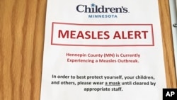 A sign at the specialty clinic at Children's Minnesota in Minneapolis alerts patients to a measles outbreak in the area, May 2, 2017. In interviews with Somali mothers in Minnesota, VOA's Somali Service found that anti-vaccine views are widespread.