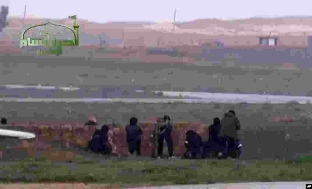 This image taken from video shows Syrian rebels at Jarrah airfield in Aleppo province, February 12, 2013. 
