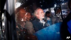 Christian James Michel, center, a British man accused of bribery in a $670 million helicopter deal between India and an Italian defense company returns after appearing before a Central Bureau of Investigation court in New Delhi, Dec.5, 2018. 
