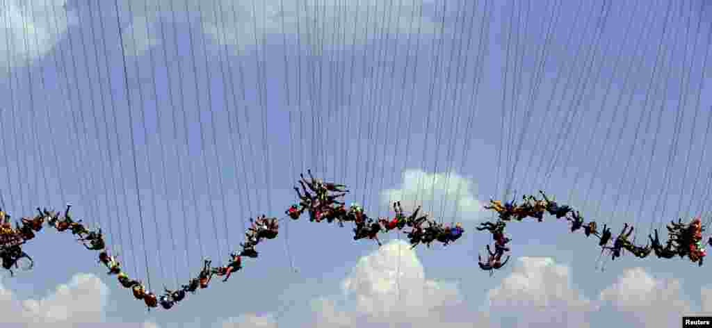 ۱۴۹ نفر با هم از روی یک پل به ارتفاع سی متر در برزیل به پایین می پرند تا رکورد پرش با طناب از نظر تعداد را بزنند.