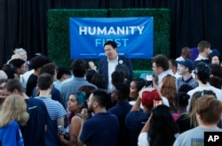 Democratic presidential candidate and entrepreneur Andrew Yang, center, meets with people at a campaign event Tuesday, April 23, 2019, in Las Vegas. (AP Photo/John Locher)