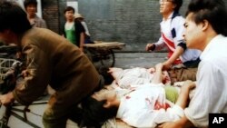 FILE - In this June 4, 1989, photo, a rickshaw driver transports wounded people, with the help of bystanders, to a nearby hospital in Beijing after they were injured during clashes with Chinese soldiers in Tiananmen Square. 