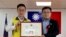 FILE - In this June 20, 2019, photo released by Pingtung County Fangliao Township Office, Lee Meng-chu, right, accepts a certificate for his adviser role during a ceremony in Pingtung County, Southern Taiwan. 