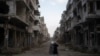 FILE - Women talk on a street surrounded by buildings that were destroyed during the civil war at the district of Khalidiya in Homs, Syria, Jan. 1, 2025.