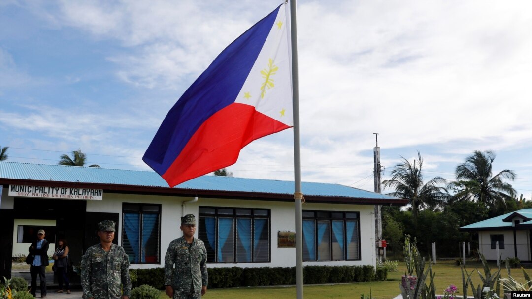 ARSIP - Serdadu-serdadu Filipina bersiaga di samping bendera Filipina di pulau Thitu, sebuah pulau yang dipersengketakan di Laut China Selatan, 21 April 2017 (foto: Reuters/Erik de Castro)