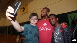 Isaiah Mustafa , centro la imagen de Old Spice posa para un selfie con estudiantes. La tendencia es usar las redes sociales para llegar a los públicos más jóvenes.